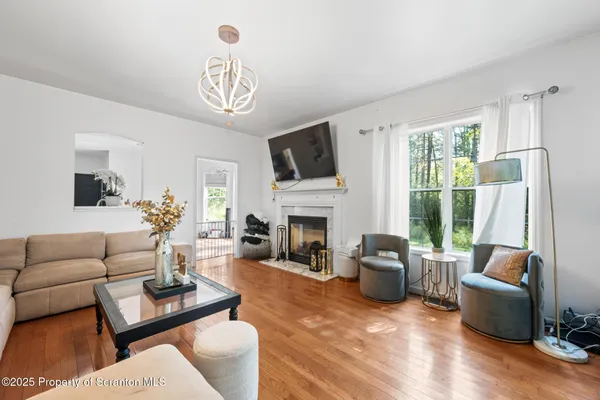 a living room with furniture a fireplace a flat screen tv and a large window