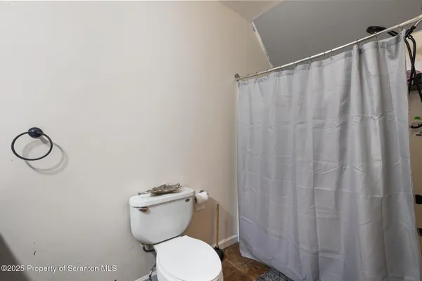 a white toilet sitting next to a shower curtain