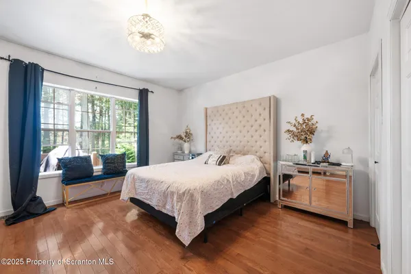 a bedroom with a bed furniture and a large window