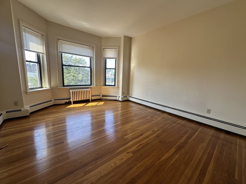 1238 Commonwealth Avenue, Unit 51 Boston, MA 02134 - Photo 1 of 10 an empty room with wooden floor and windows