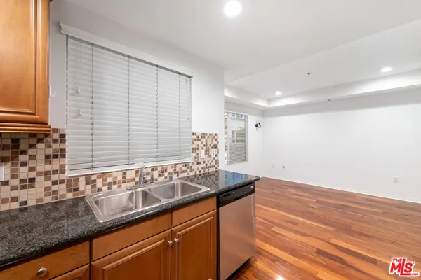 a kitchen with granite countertop white cabinets and a sink