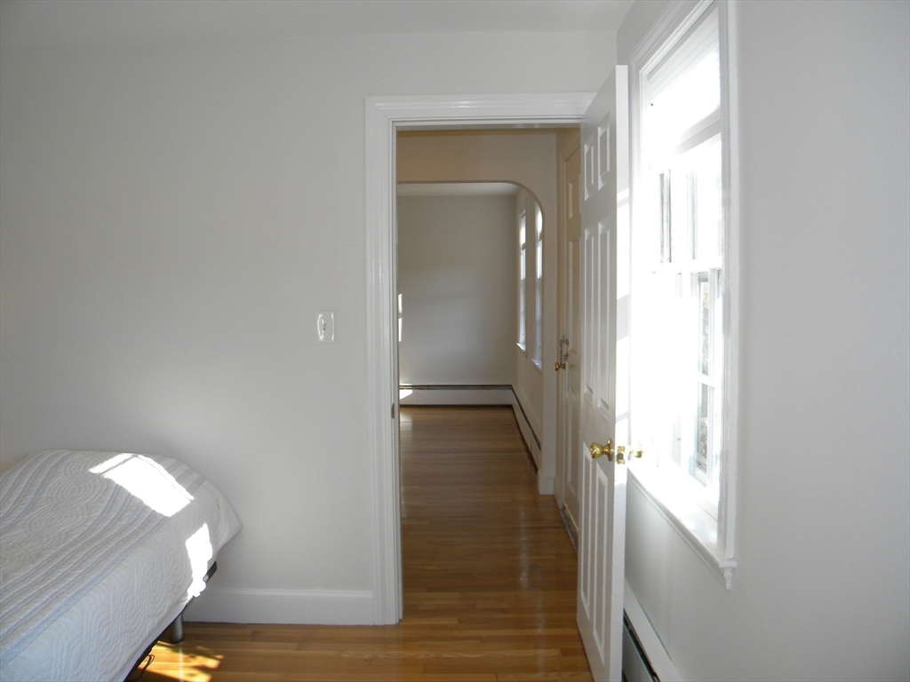 21 Lovers Lane Groton, MA 01450 - Photo 14 of 35 a view of a hallway with wooden floor and glass door