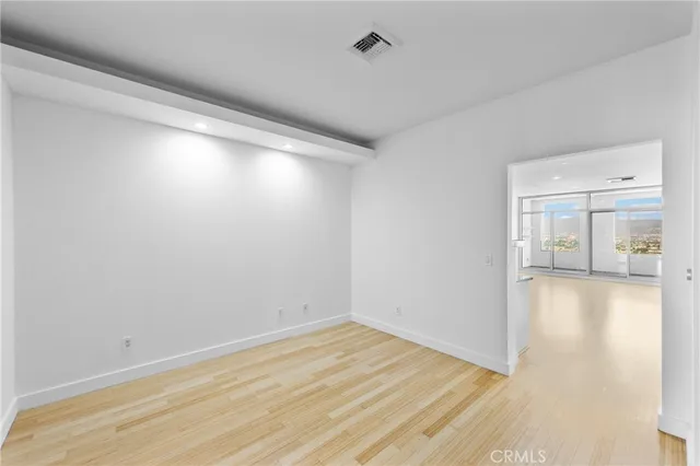 a view of empty room with wooden floor
