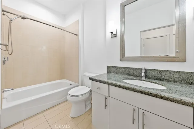 a bathroom with a granite countertop sink a toilet and shower