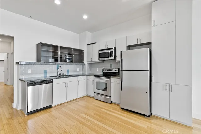 a kitchen with stainless steel appliances a refrigerator sink and microwave