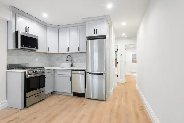 a kitchen with stainless steel appliances a stove a microwave and a refrigerator