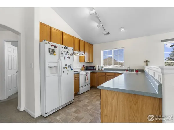 a kitchen with refrigerator and cabinets
