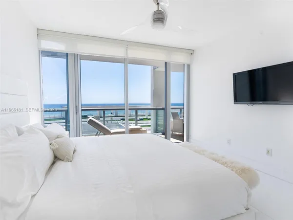 a large bedroom with a large window and a flat screen tv