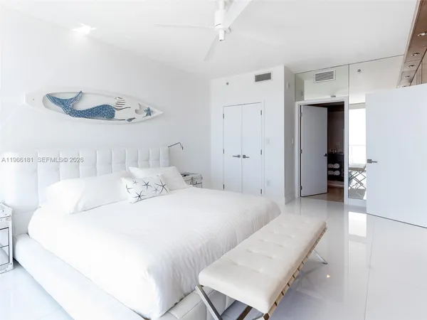 a spacious bedroom with a bed and a chandelier