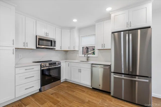 a kitchen with stainless steel appliances granite countertop a refrigerator stove a sink and a microwave