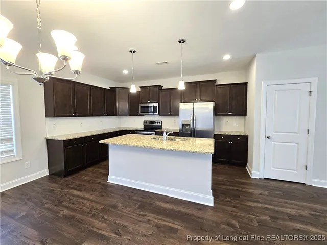 a large kitchen with kitchen island a sink stainless steel appliances and cabinets