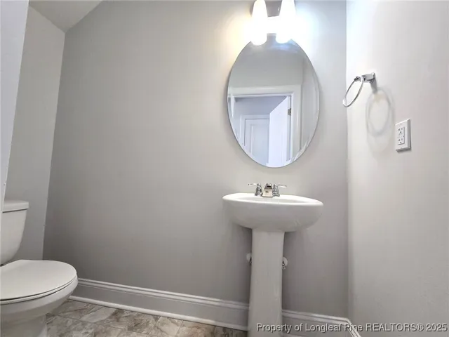 a bathroom with a toilet a sink and a mirror