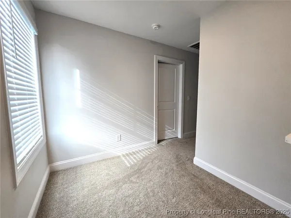 a view of a room with a ceiling fan and a window