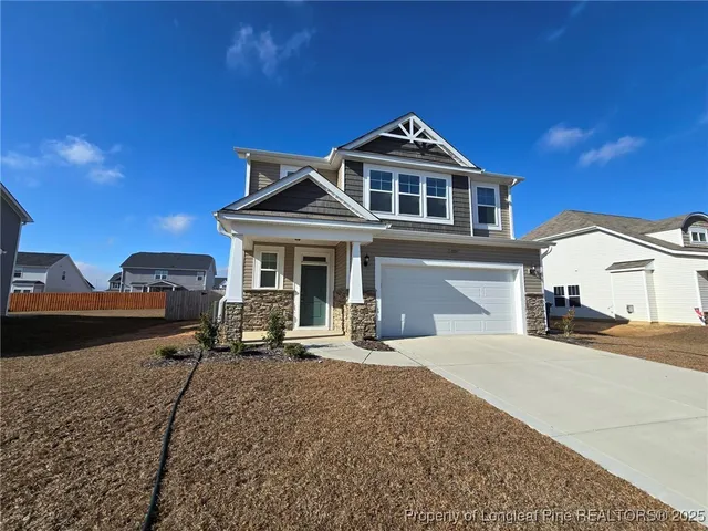 a front view of a house with yard and parking space