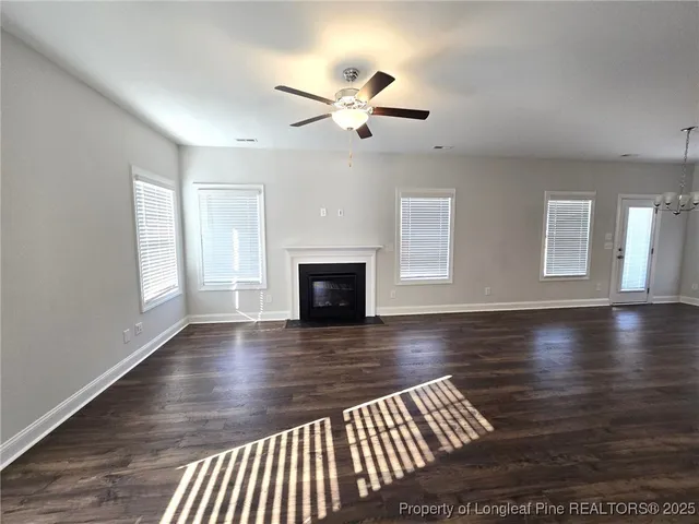 a view of empty room with wooden floor and fireplace