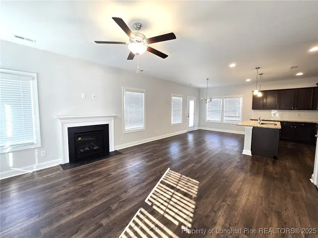 an open kitchen with wooden floor and a fireplace