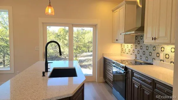 a kitchen with a sink a counter top space and stainless steel appliances
