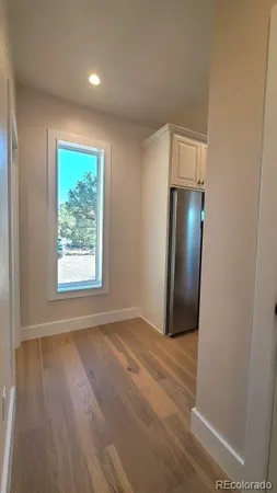 an entryway with wooden floor and cabinet