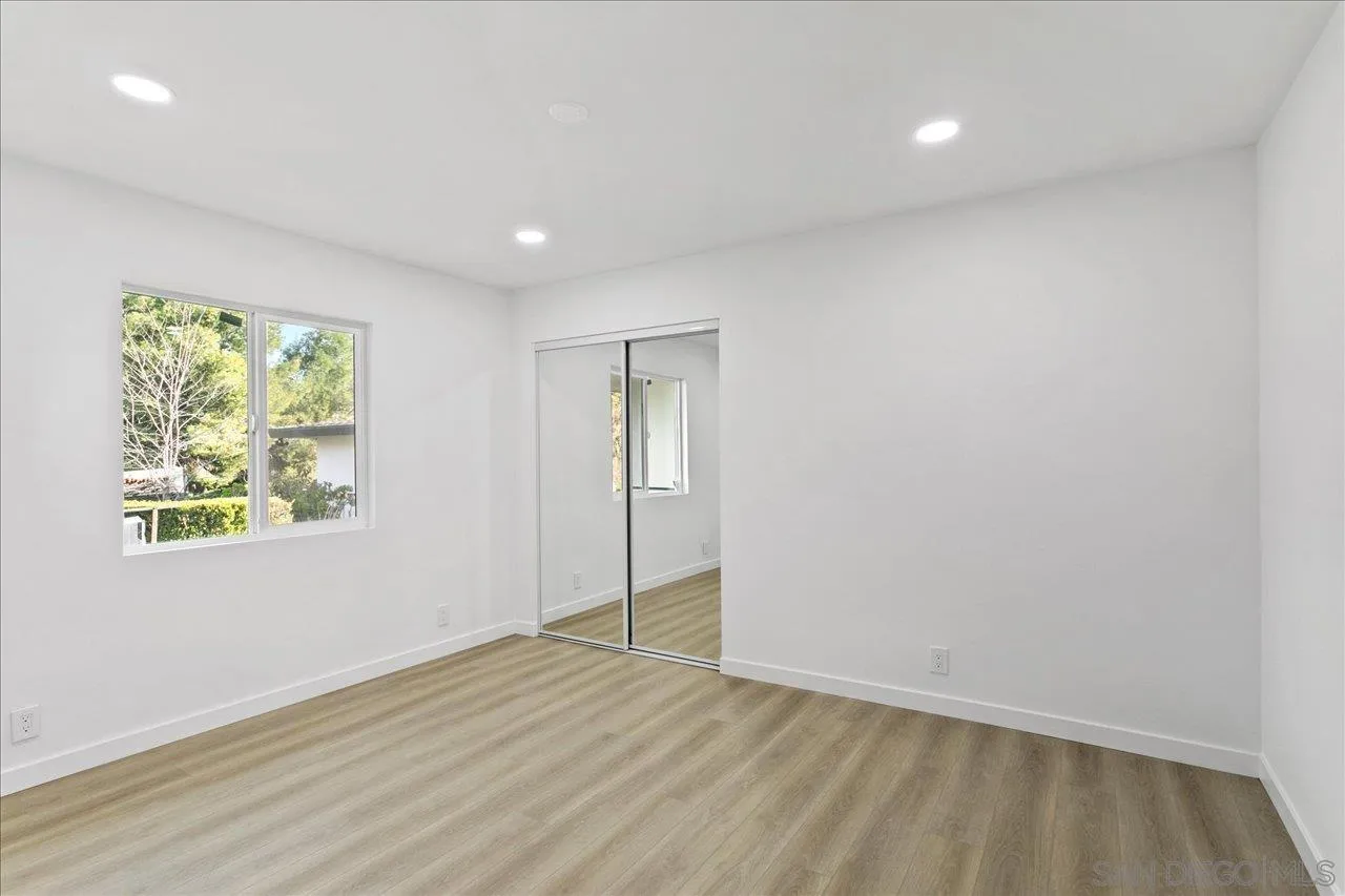 506 Brotherton Road Escondido, CA 92025 - Photo 20 of 31 an empty room with wooden floor and windows
