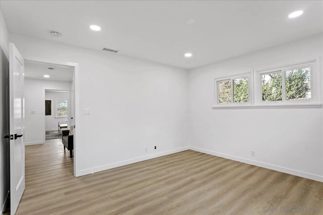 506 Brotherton Road Escondido, CA 92025 - Photo 21 of 31 an empty room with wooden floor and windows