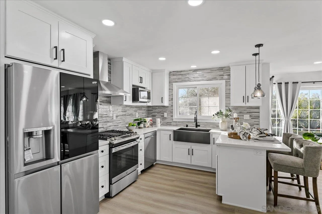 506 Brotherton Road Escondido, CA 92025 - Photo 9 of 31 a kitchen with white cabinets and stainless steel appliances
