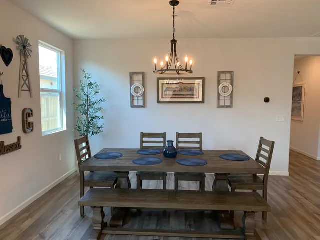 a kitchen with stainless steel appliances kitchen island granite countertop a refrigerator a sink dishwasher a stove and white cabinets with wooden floor