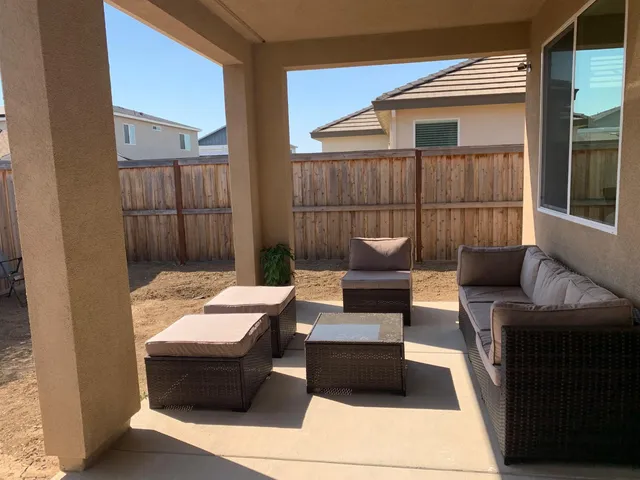 a outdoor space with patio couches and a fireplace