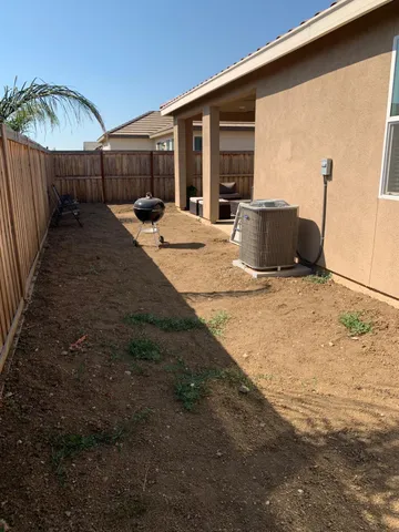 a backyard of a house with table and chairs