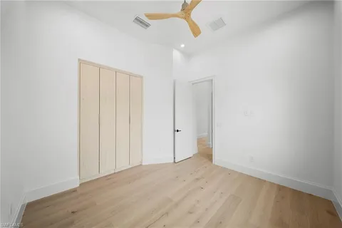 a view of an empty room and chandelier fan