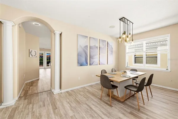 a view of a dining room with furniture a chandelier and wooden floor