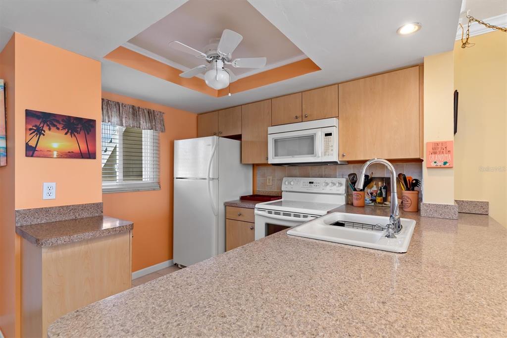 25275 Rampart Boulevard, Unit 202 Punta Gorda, FL 33983 - Photo 10 of 28 a kitchen with stainless steel appliances granite countertop a refrigerator stove top oven a sink and dishwasher