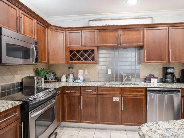a kitchen with granite countertop a sink stove and microwave