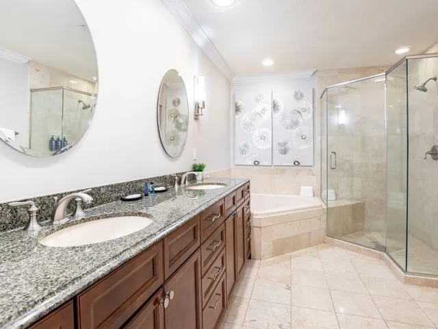 a spacious bathroom with a granite countertop sink mirror and bathtub
