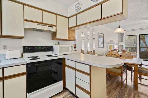 a view of a livingroom and dining room with furniture wooden floor chandelier