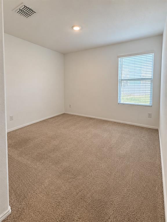 11726 Bone Spg Drive Rhome, TX 76078 - Photo 25 of 29 Well-sized secondary bedroom featuring neutral carpeting, recessed lighting, and a large window for natural light.