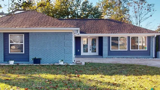 a view of a brick house with a yard