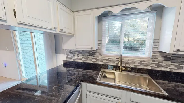 a kitchen with granite countertop a sink and a window