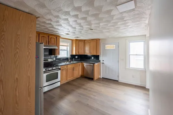 a kitchen with stainless steel appliances granite countertop a stove a sink and a microwave