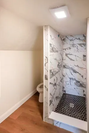 a bathroom with a toilet and a shower