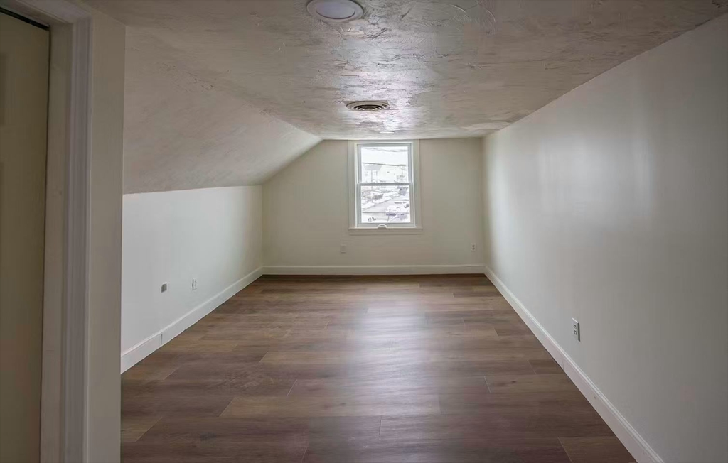281 Beach Street, Unit 2 Revere, MA 02151 - Photo 7 of 17 an empty room with wooden floor and windows