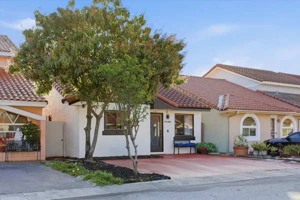 a front view of a house with a yard and potted plants