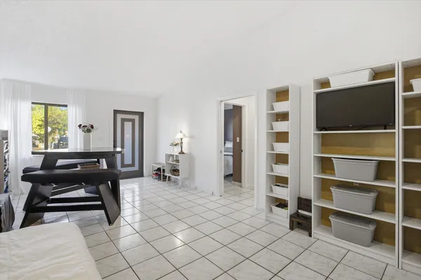 a living room with furniture a flat screen tv and a window