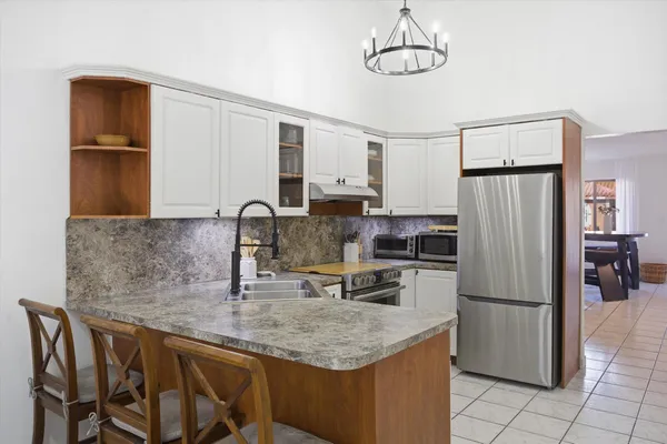 a kitchen with stainless steel appliances granite countertop a sink refrigerator and microwave