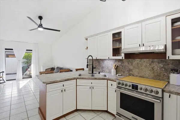 a kitchen with stainless steel appliances granite countertop a sink stove and cabinets