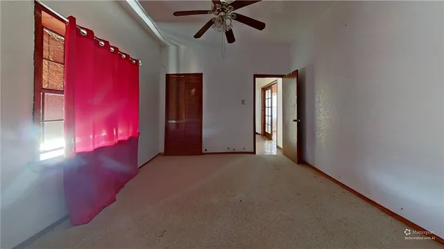 a view of a livingroom with a ceiling fan and window