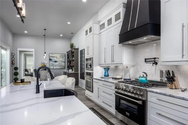 a kitchen with kitchen island granite countertop a stove and a sink