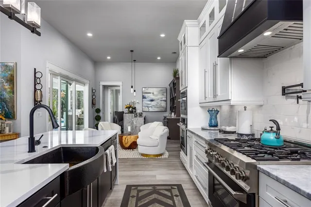 a living room with furniture kitchen area and a wooden floor