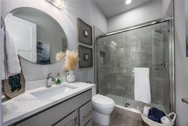 a bathroom with a granite countertop sink and a shower