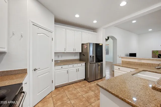 a kitchen with a sink dishwasher a stove and white cabinets with wooden floor