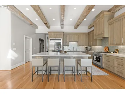 a dining hall with stainless steel appliances kitchen island a table and chairs